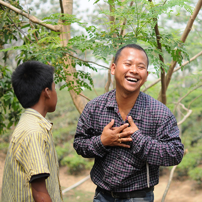 Tea farmer and child in tea garden laugh